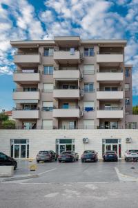 a large apartment building with cars parked in a parking lot at Apartment Boka View in Kotor