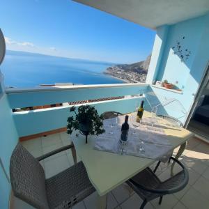 a table with a bottle of wine and glasses on a balcony at Apartments Milina in Omiš