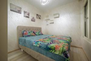 a small bedroom with a bed with a colorful comforter at Apartment Boka View in Kotor