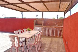 een houten tafel en stoelen op een patio bij Chalet Brisa Veraniega in Conil de la Frontera