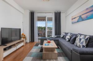a living room with a couch and a tv at Sea View Apartment Michelle near Osejava in Makarska