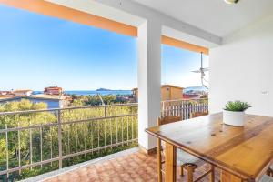 Habitación con mesa y balcón con vistas. en Casa Cala Biriala, en Santa Maria Navarrese