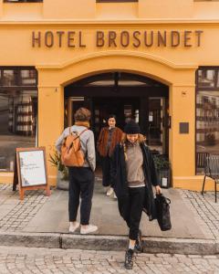 een groep mensen die een hotelgebouw binnenlopen bij Hotel Brosundet in Ålesund
