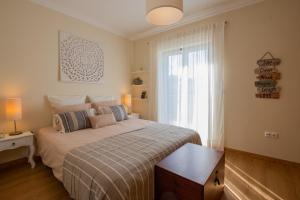 a bedroom with a large bed and a window at MilDreams House in Vila Nova de Milfontes