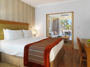 a hotel room with a large bed and a balcony at Olympic Lagoon Resort Ayia Napa in Ayia Napa
