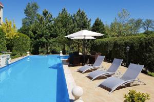 a swimming pool with lounge chairs and an umbrella at holiday home, Trzesacz in Trzęsacz