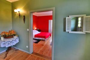 a bedroom with a red bed and a room with a table at Comfortable 2 person holiday apartment in the countryside Drezno in Stare Wierzchowo