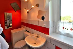 a bathroom with a toilet and a sink and a window at Comfortable 2 person holiday apartment in the countryside Drezno in Stare Wierzchowo
