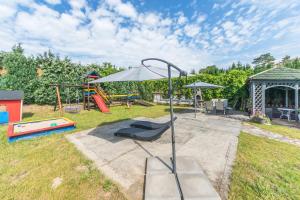 a playground with an umbrella and a slide at Aparthotel Luna&Sol in Jastrzębia Góra