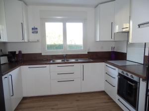 a kitchen with white cabinets and a sink and a window at Comfortable holiday home between Cote Sauvage and sandy beaches in Saint-Pierre-Quiberon