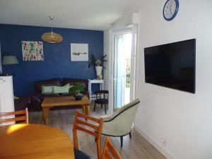 uma sala de estar com um sofá e uma televisão na parede em Comfortable holiday home between Cote Sauvage and sandy beaches em Saint-Pierre-Quiberon