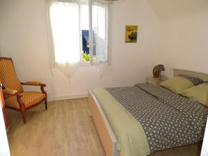um quarto com uma cama, uma cadeira e uma janela em Comfortable holiday home between Cote Sauvage and sandy beaches em Saint-Pierre-Quiberon