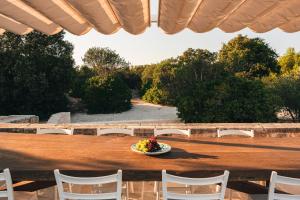 eine Obstschale auf einem Tisch mit weißen Stühlen in der Unterkunft HelloAPULIA - Masseria Minetta - Infinity Saltwater Pool & Scenic View in Cisternino + 37 Fotos