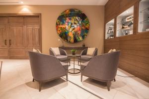a dining room with chairs and a painting on the wall at Crowne Plaza Porto by IHG in Porto
