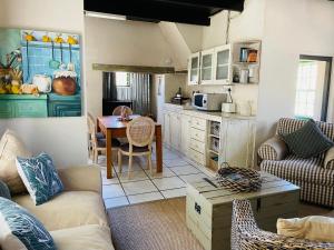 a living room with a couch and a table at Kleine Vrede Farm Cottage in Hermanus