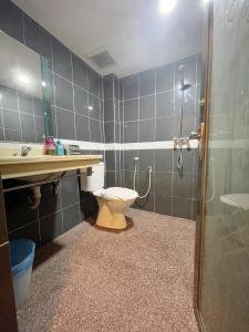 a bathroom with a toilet and a sink and a shower at City Boutique Hotel - Bangi in Bangi