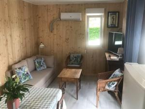 ein Wohnzimmer mit einem Sofa und einem Tisch in der Unterkunft Chalet "Belle-Etoile" Touraine Anjou avec piscine in Courcelles-de-Touraine