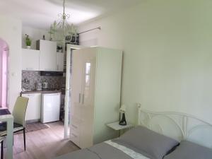 um quarto branco com uma cama e uma cozinha em Apartment Zara em Crikvenica