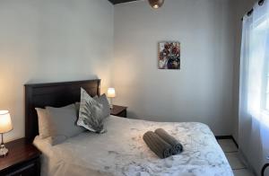 a bedroom with a bed with two pillows on it at Kleine Vrede Farm Cottage in Hermanus