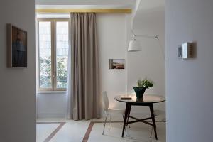 comedor con mesa y ventana en Corso Novara 5 Design Apartments, en Nápoles