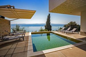 - une piscine dans une maison avec vue sur l'eau dans l'établissement Villa Gust with heated pool, jacuzzi, sauna and cinema, à Celina