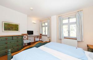 a bedroom with a bed and a desk and window at Landgasthaus Ziegelscheune in Krippen