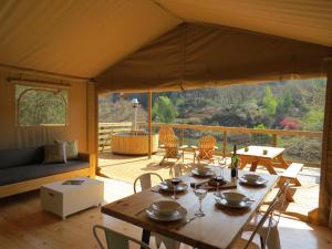a dining room with a table and chairs in a tent at AfriCamps Magoebaskloof in Magoebaskloof