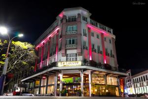 un edificio con luces rosas en la parte delantera en Le Louvre Hotel & Spa, en Antananarivo