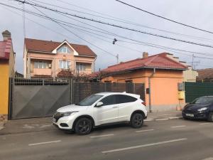 um carro branco estacionado em frente a uma casa em Casuta Lavi Constanta em Constança