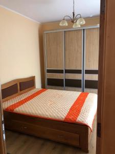 um quarto com uma cama com um edredão laranja e branco em Casuta Lavi Constanta em Constança