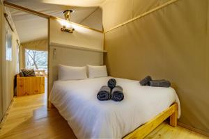 a bedroom with a bed with shoes on it at AfriCamps Hoedspruit in Hoedspruit +24 photos