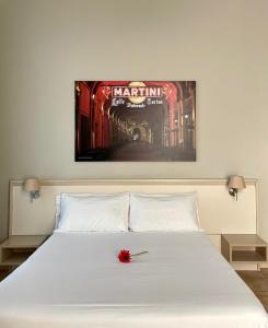 a bed with a white bedspread and a picture on the wall at Best Quality Hotel Dock Milano in Turin