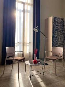 sala de estar con 2 sillas, mesa y lámpara en Best Quality Hotel Dock Milano, en Turín