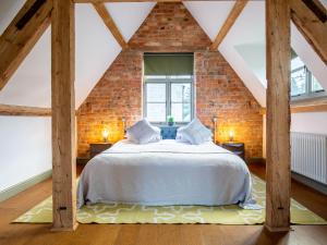 ein Schlafzimmer mit einem weißen Bett im Dachgeschoss in der Unterkunft The Hayloft in Winchcombe