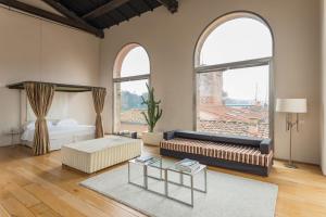 a living room with a couch and two windows at Riva Lofts Florence in Florence +93 photos