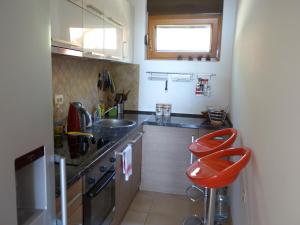una cucina con lavandino e 2 sgabelli rossi di Orahovac Bayview a Kotor (Cattaro)