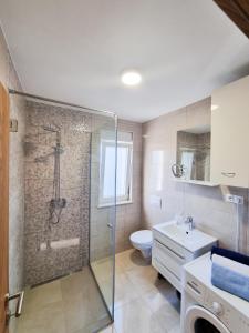 La salle de bains est pourvue d'une douche, de toilettes et d'un lavabo. dans l'établissement Apartment Ane 2, à Tisno