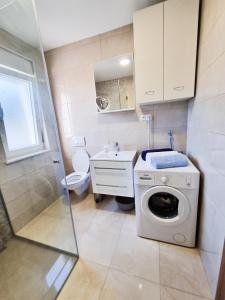 La salle de bains est pourvue d'un lave-linge et d'un lavabo. dans l'établissement Apartment Ane 2, à Tisno