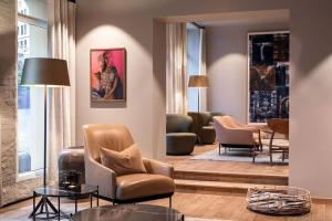 a living room with chairs and tables in a building at Hotel Brosundet in Ålesund