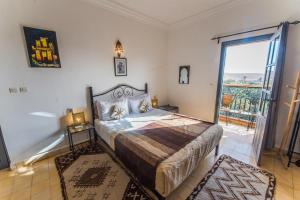 a bedroom with a bed and a door to a balcony at Riad Dar Bab Todra in Tinerhir