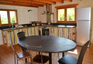 eine Küche mit einem Tisch mit Stühlen und einem Kühlschrank in der Unterkunft Maison accueillante à Gembrie avec piscine partagée in Gembrie + 9 Fotos