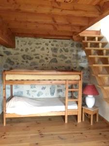 ein Etagenbett aus Holz in einem Zimmer mit einer Treppe in der Unterkunft Maison accueillante à Gembrie avec piscine partagée in Gembrie