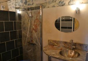 y baño con lavabo y ducha. en Maison de 2 chambres avec piscine partagee jardin clos et wifi a Gembrie, en Gembrie