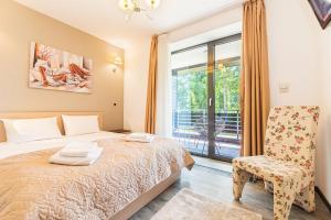 una camera con un letto e una sedia e una finestra di Fabulous Views Silver Mountain 3 Rooms Apartment a Poiana Brasov