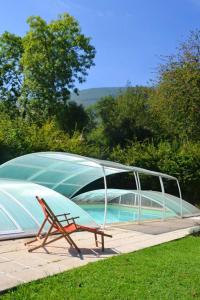 un banco sentado junto a una piscina con cubierta en Maison d'une chambre avec piscine partagee jardin clos et wifi a Gembrie, en Gembrie