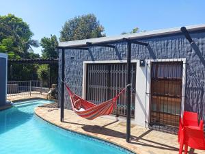 a hammock on a patio next to a swimming pool at Panorama Indlu in Cape Town