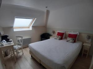 a bedroom with a large bed and a window at Les Embruns in Trouville-sur-Mer