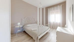 een witte slaapkamer met een bed en een raam bij Case Playa in Balestrate