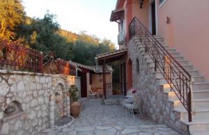 a building with a staircase next to a stone wall at Horizon Blue, Kalamitsi, Lefkas in Kalamitsi