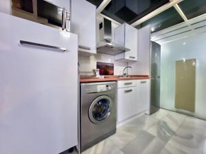 biała kuchnia z pralką w obiekcie Charming Madrid Río II w Madrycie